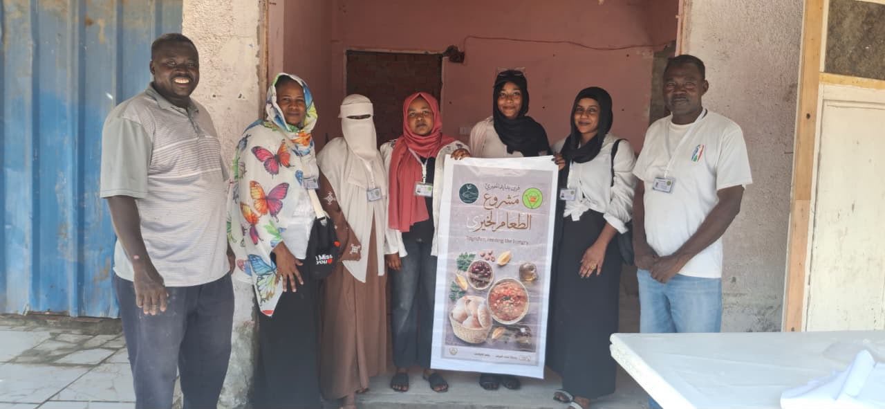 Seven members of the Bidaya team standing together, holding a poster for the food project.